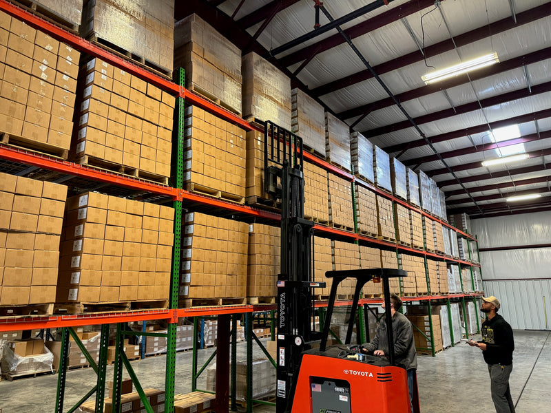 People working in warehouse with forklift